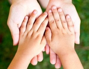Child's hands inside of adult's hands